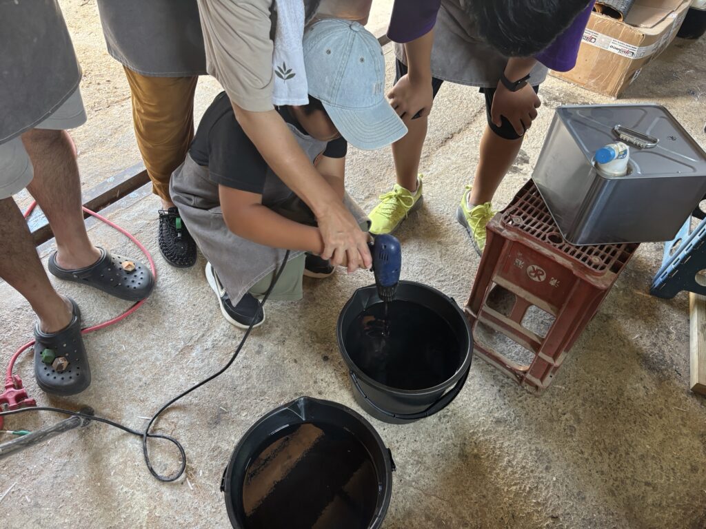 家族でレジンを混ぜる体験をしている様子。お子様が電動ドリルを操作している。