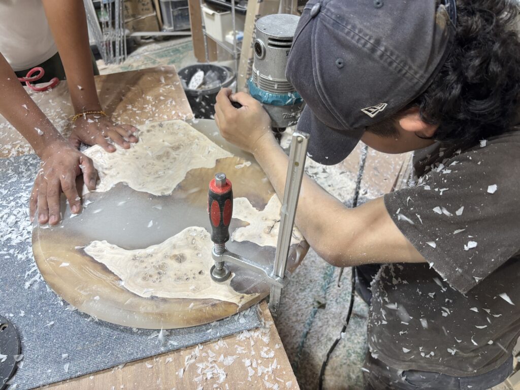 レジンテーブルを固定して縁を加工する研修風景