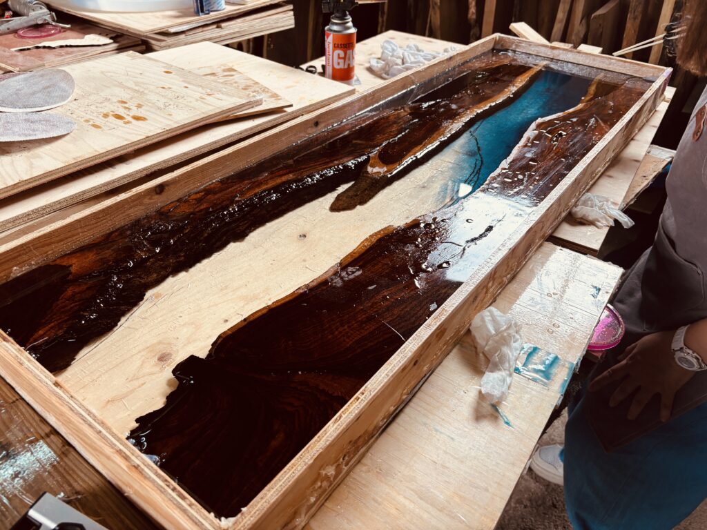 ブルーとクリアのレジンを型枠に流し込む制作工程