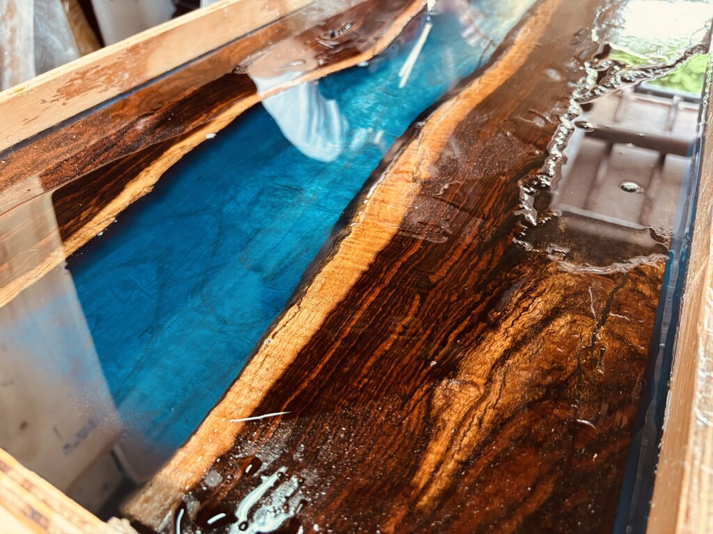 ワークショップで制作中のレジンテーブル、ブルーレジンと木目が織りなす美しいアップ写真