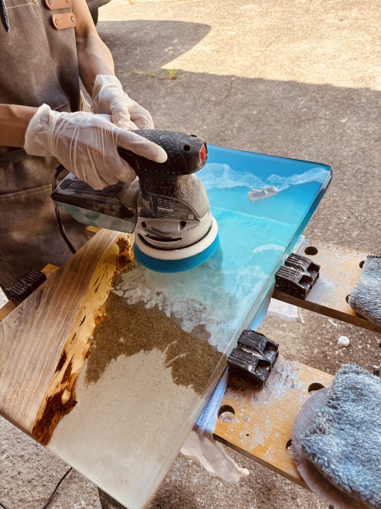 電動サンダーでレジンテーブルを研磨する様子