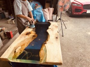 青く透明なレジンを磨き上げて仕上げに取り掛かるレジンテーブル制作体験