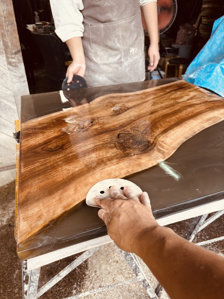 レジンテーブルの表面を手作業で仕上げる研磨風景