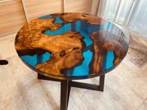 直径1200mmのカンファーウッド×ブルーレジンのラウンドテーブル全体を俯瞰で撮影。世界地図のような動きのある木目と鮮やかなレジンが特徴。