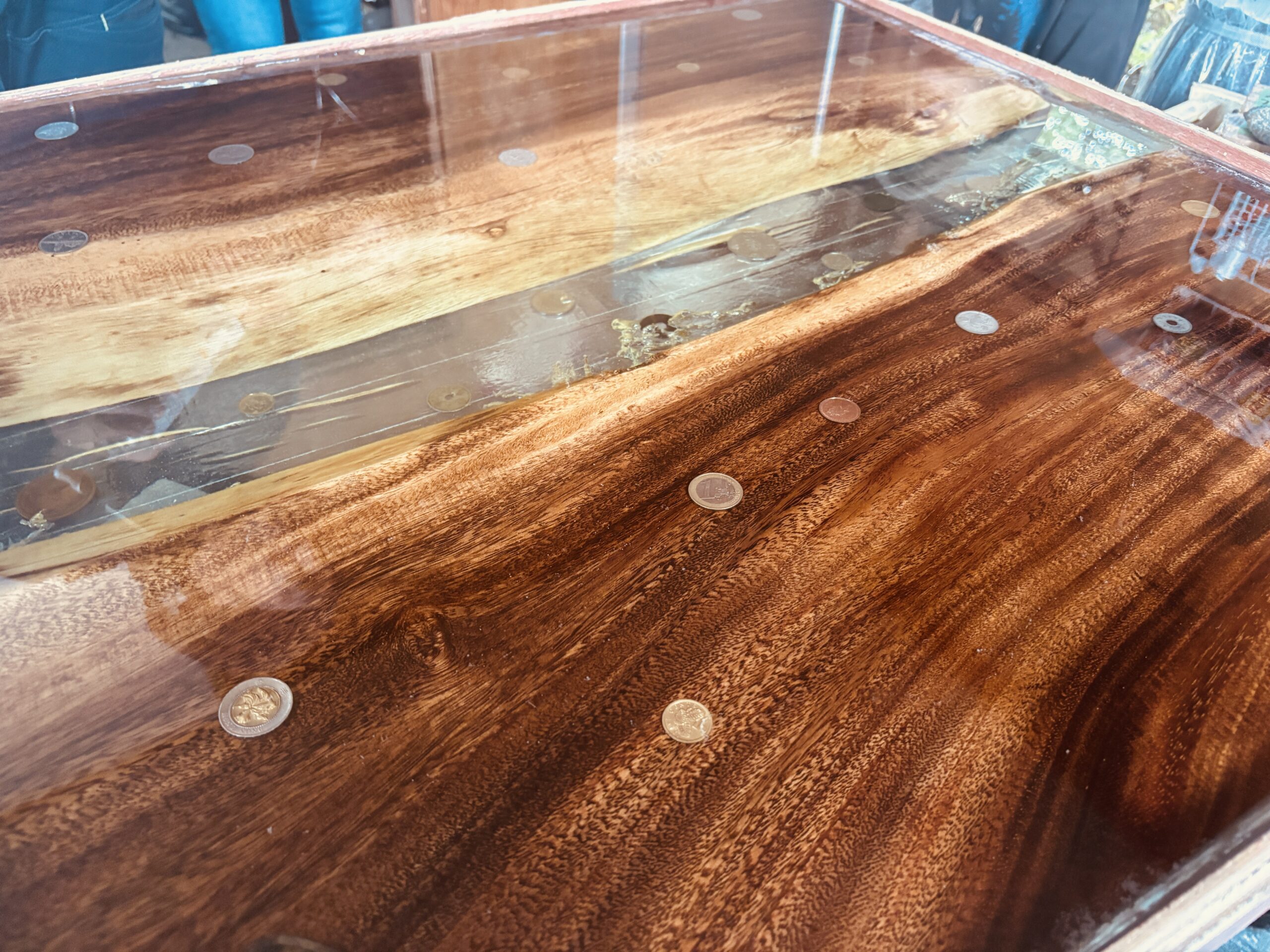 仕上げ工程に入った古銭入りレジンテーブル。レジンが硬化し、光沢感が増している様子。