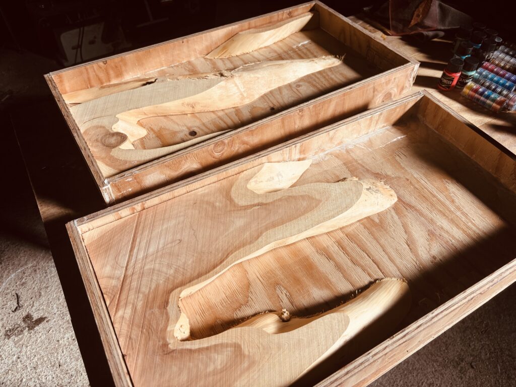 木枠の型に奈良県産カイヅカイブキを配置し、レジンテーブル制作の下準備を行っている様子。