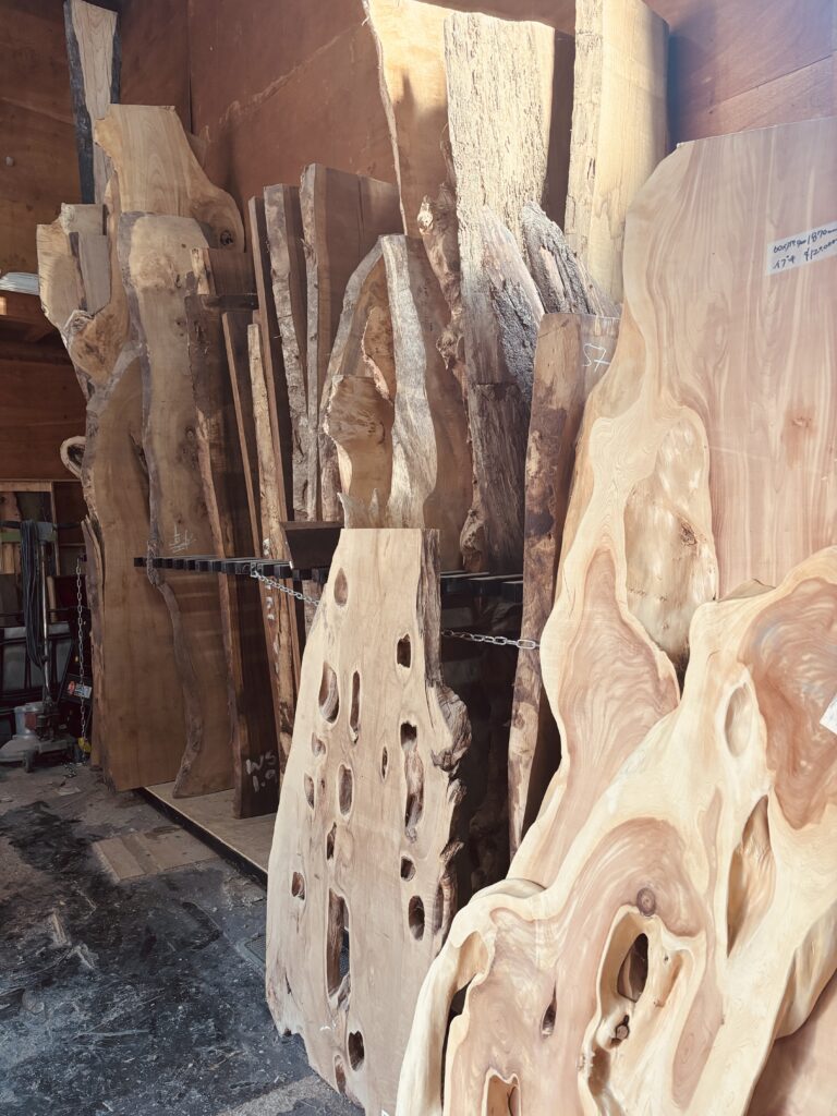 アトリエ内に立てかけられた無垢板のストックと、乾燥中のレジンテーブル。