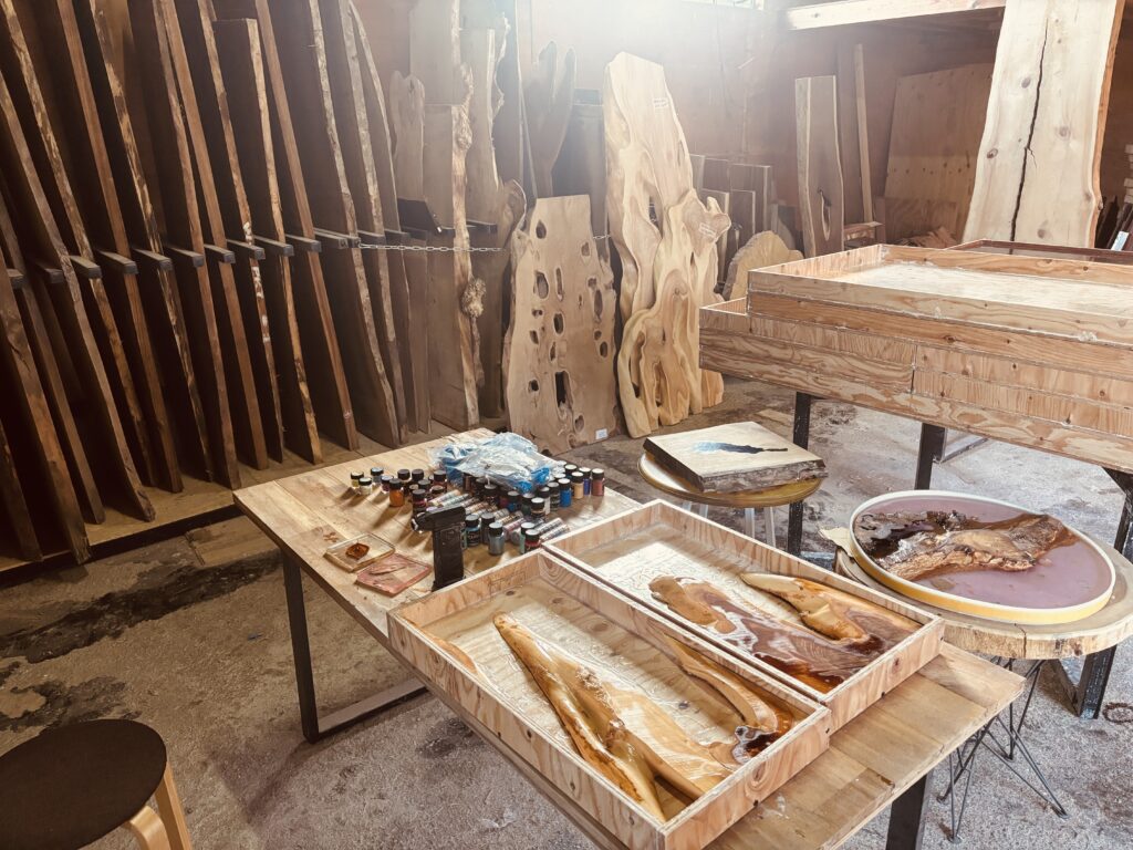 レジンの着色パウダーや工具が並ぶ作業台と、片付け中のアトリエ全景。