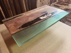 パオロサ材と透明感のあるグリーンレジンを組み合わせたレジンテーブル天板。深い色味の木目とクリアなレジンが対比的に輝く仕上げ。