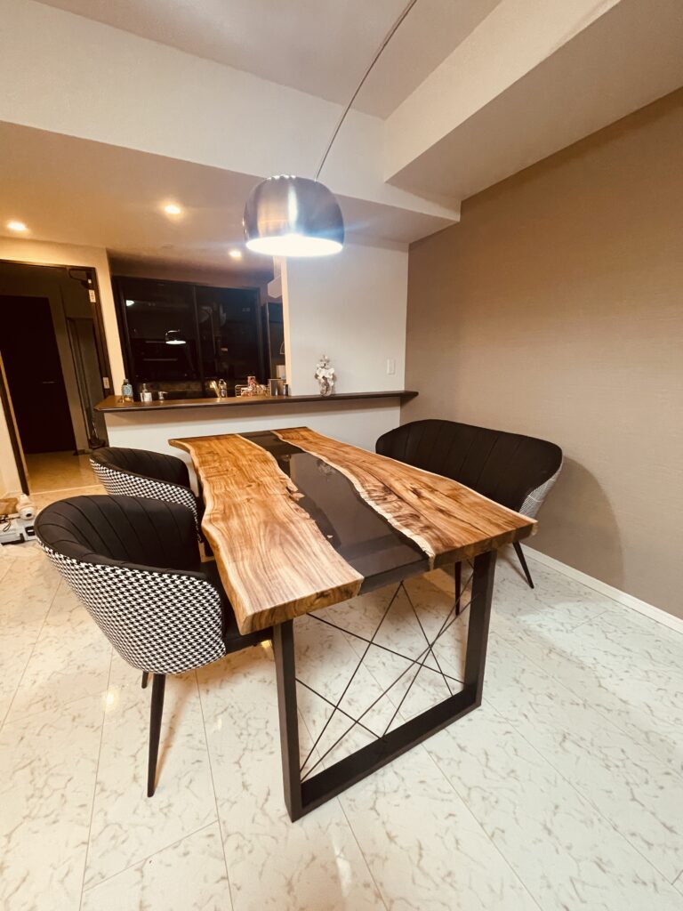 モダンな照明の下で輝くブラックウォルナットとグレーレジンのテーブル。