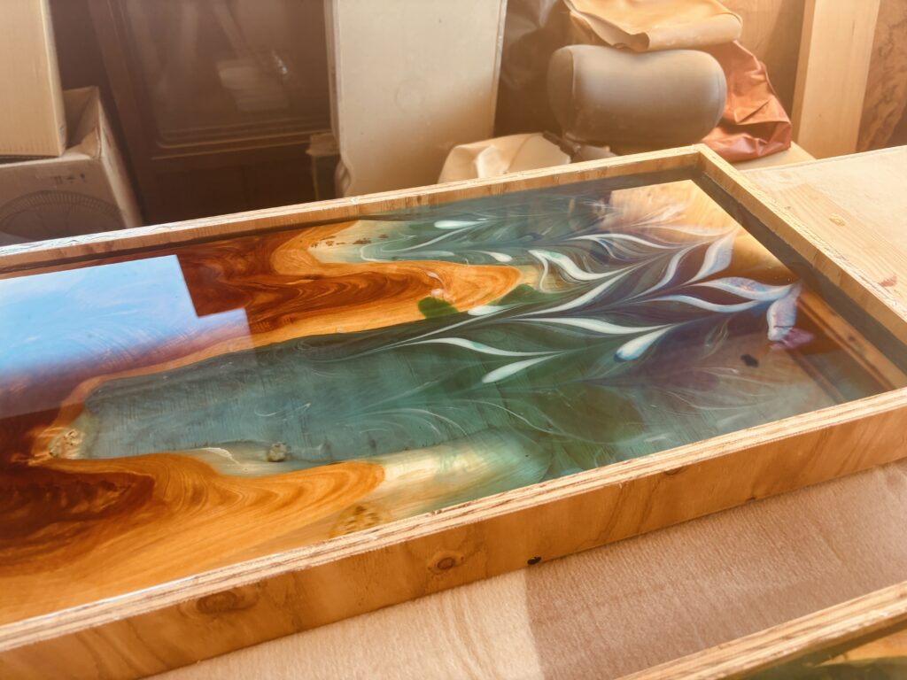 模様を描いた直後のレジンテーブル天板。時間とともに色が馴染んでいく過程の一場面。