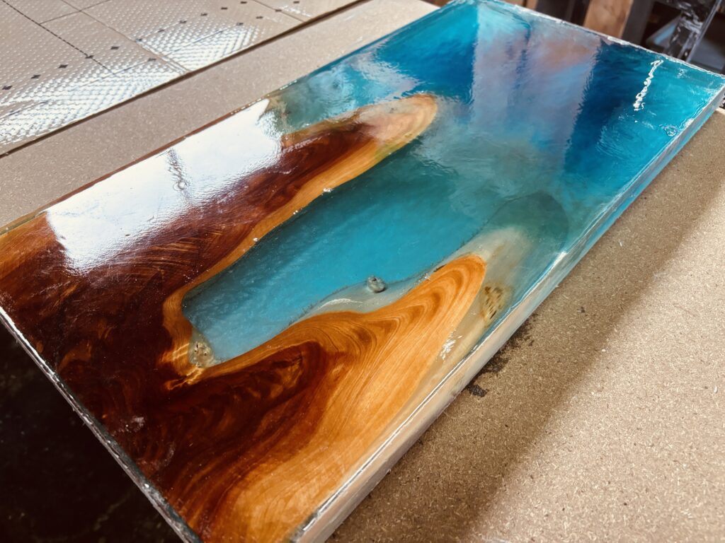 ブルーをベースにグリーンやホワイトが溶け込んだレジンテーブル。カイヅカイブキの赤身が映える。