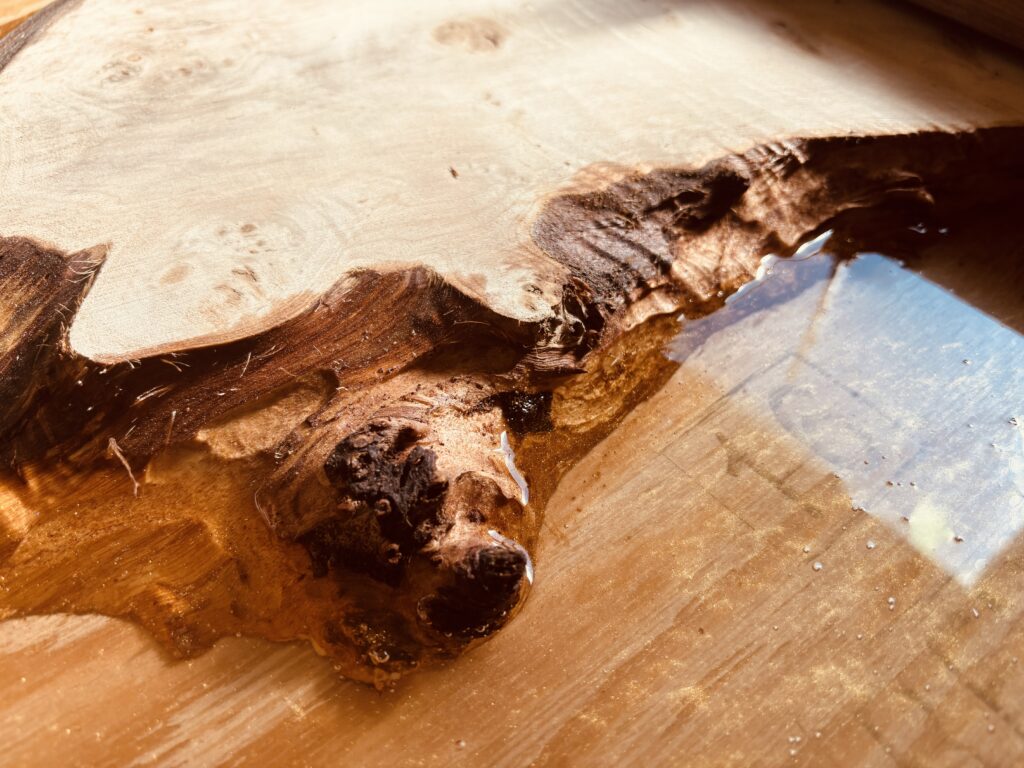 ポプラ材の瘤にゴールドのレジンが流し込まれたレジンテーブル制作途中のアップ写真