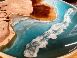 沖合の深いブルーグリーンから浅瀬へと続くグラデーションと立体的な波を表現した地中海イメージのレジンテーブル斜め視点写真