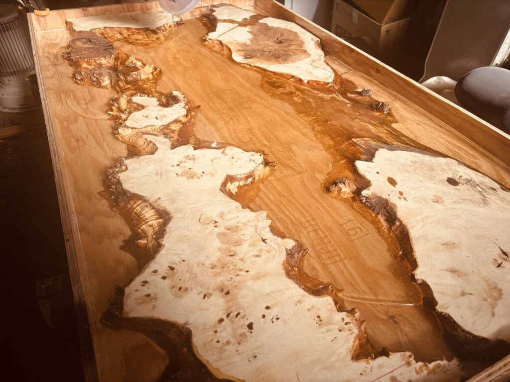 木枠を組んだ状態でポプラ材を配置し、ゴールドパールのレジンを流し込んでいる制作途中のレジンテーブル。