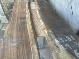 モンキーポッドの一枚板を乾燥状態のまま立てかけた様子。色ムラと木目のコントラストを確認している素材選定段階。