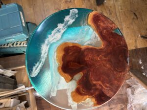 海をイメージしたターコイズブルーのレジンと無垢材を組み合わせたラウンドテーブルの天板全体