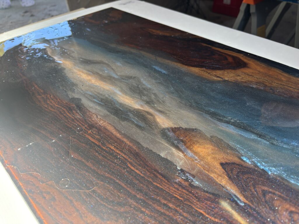 アフリカンブラックウッドとブルーパールのレジンが雲流のように重なり合うレジンテーブル天板のアップ写真