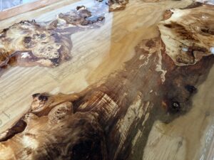 硬化したレジンの層が重なり合い、木目と金色の顔料が奥行きのある表情を生み出しているレジンテーブル制作途中の様子。