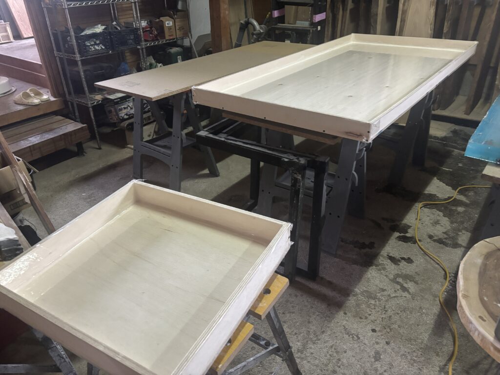 工房内で制作中のレジンテーブル用木枠。サイズごとに組まれた木枠が作業台の上に並んでいる様子