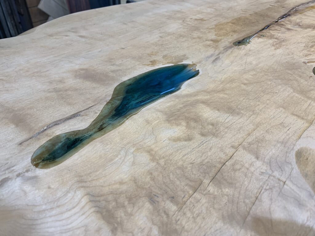 トチノキの木目とブルーのレジンが自然につながる割れ部分のクローズアップ。