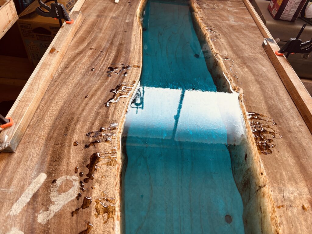 モンキーポッドの耳付き板にアクアブルーのレジンを流し込む制作工程