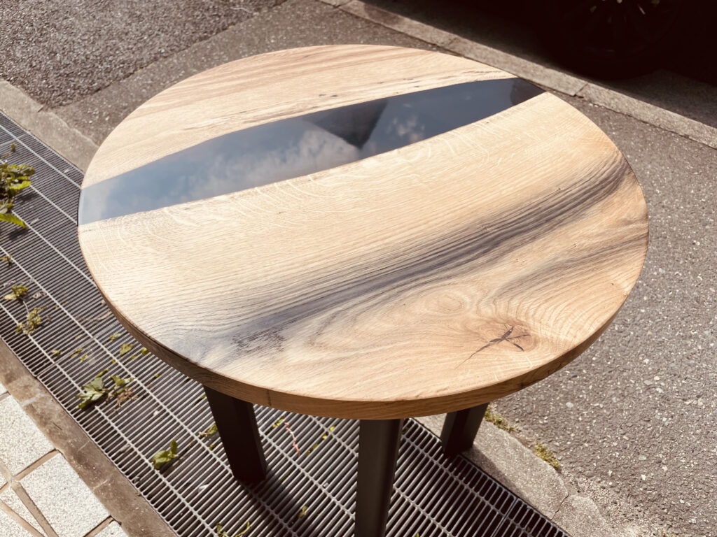 オーク無垢材とブラックレジンを組み合わせたラウンドレジンテーブルの全体像 屋外で撮影された丸テーブル