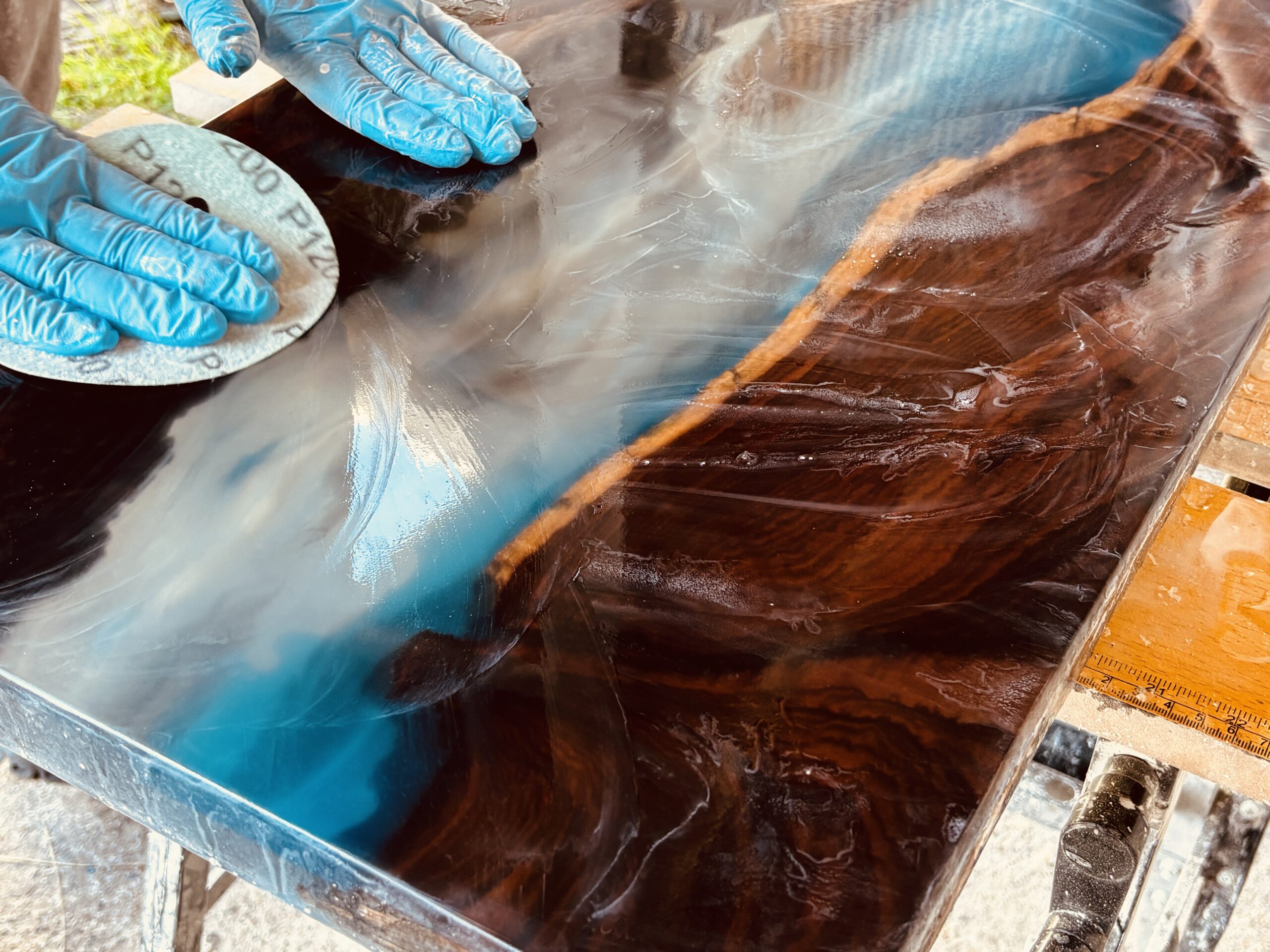 レジンテーブル製作体験ワークショップで大阪から参加されたご夫婦が御所市の工房で天板の水研磨を行っている様子