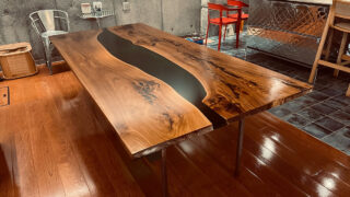 カンファーウッド（クスノキ）の無垢一枚板を使用した幅1100mm・長さ2400mm・厚さ60mmの大型レジンテーブル。ブラックレジンが流れるように配置されたダイニングテーブル。