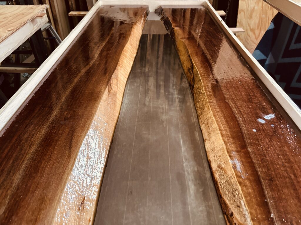 ブラックウォルナットの一枚板にスモークグレーのレジンを流し込んだ制作中のレジンテーブル。