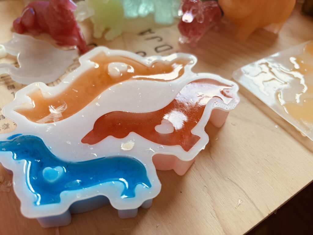シリコン型に流し込まれたカラーレジンの犬型パーツ制作中の様子