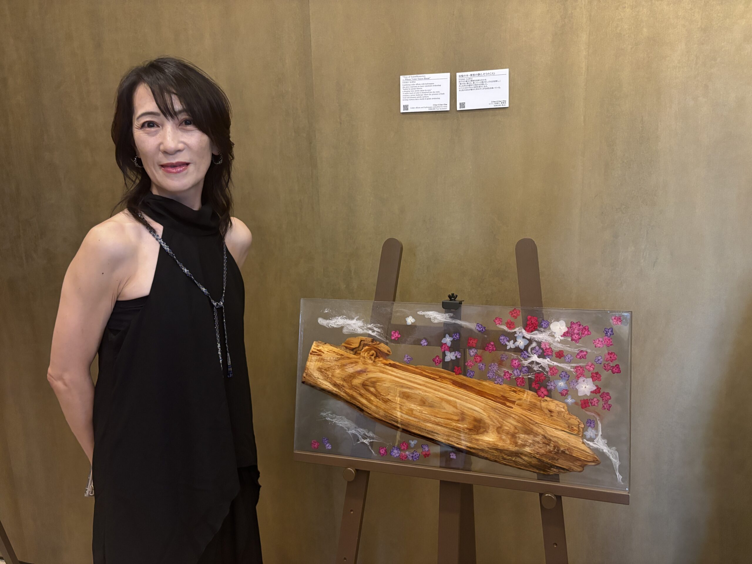 帝国ホテル大阪の展示会場でレジンアート作品と並ぶNAOKO KAWAIさん。木とレジンを使ったアート作品を展示。